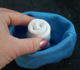 using a baby hat and baby sock make a flower for a diaper wreath